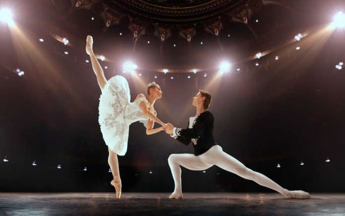 Ballet. Classical ballet performed by a couple of ballet dancers on the stage of the opera house.