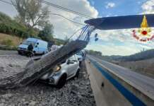 Escavatore urta cavalcavia, sotto shock conducente auto colpita da detriti