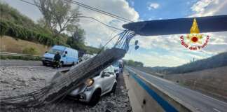 Escavatore urta cavalcavia, sotto shock conducente auto colpita da detriti