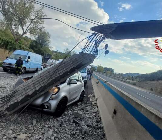 Escavatore urta cavalcavia, sotto shock conducente auto colpita da detriti